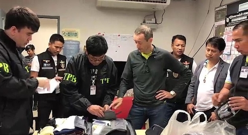 Cảnh sát kiểm tra hành lý của Patrick Coulier (áo xám, chống nạnh). Ảnh: ViralPress.