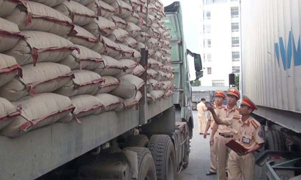 Cảnh sát kiểm đếm, lập biên bản chiếc xe vi phạm tải trọng. Ảnh: Lam Sơn.