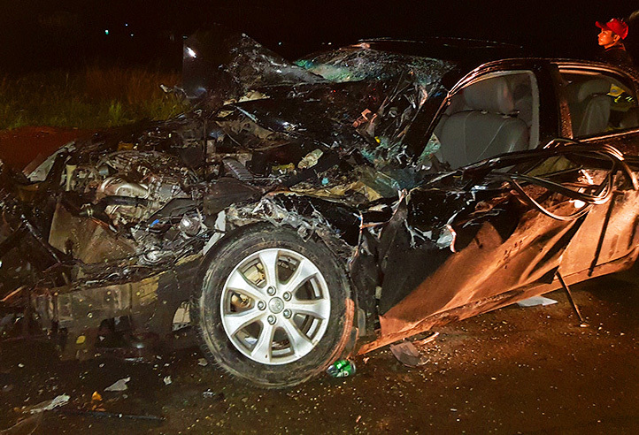 Ôtô bốn chỗ biến dạng sau khi được kéo ra khỏi đầu xe chở công nhân. Ảnh: An Nam.