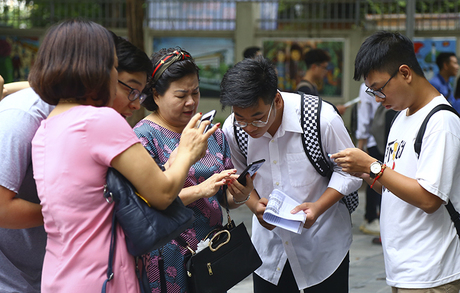 Phụ huynh và thí sinh thảo luận tại điểm thi THCS Nghĩa Tân (Hà Nội) trong ngày làm thủ tục dự thi THPT quốc gia năm 2019. Ảnh: Dương Tâm