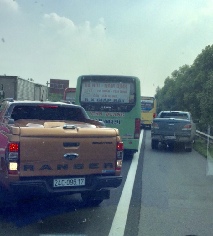 Hai ô tô nối đuôi nhau vượt trong làn khẩn  cấp.