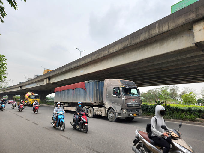 Xe container cắt nóc chở đá, xe bồn chở bêtông nối đuôi nhau hoạt động trên đường Nghiêm Xuân Yêm trong khung giờ cao điểm sáng 20/4.