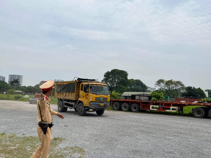 Lực lượng CSGT hướng dẫn tài xế đưa xe vào khu vực cân tải trọng và cắt thành thùng vi phạm
