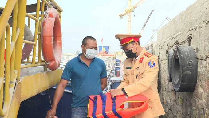 Công an TP Móng Cái hướng dẫn thuyền viên sử dụng áo phao đúng cách.