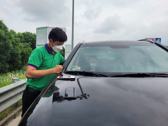 Nhân viên thực hiện dán thẻ định danh thu phí tự động cho phương tiện lưu thông trên cao tốc Đà Nẵng-Quảng Ngãi.