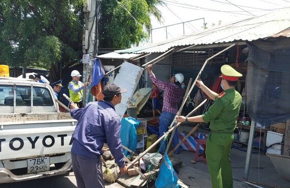 Tháo dỡ hàng quán, lều tạm lấn chiếm lề đường QL1 qua xã Tịnh Phong.
