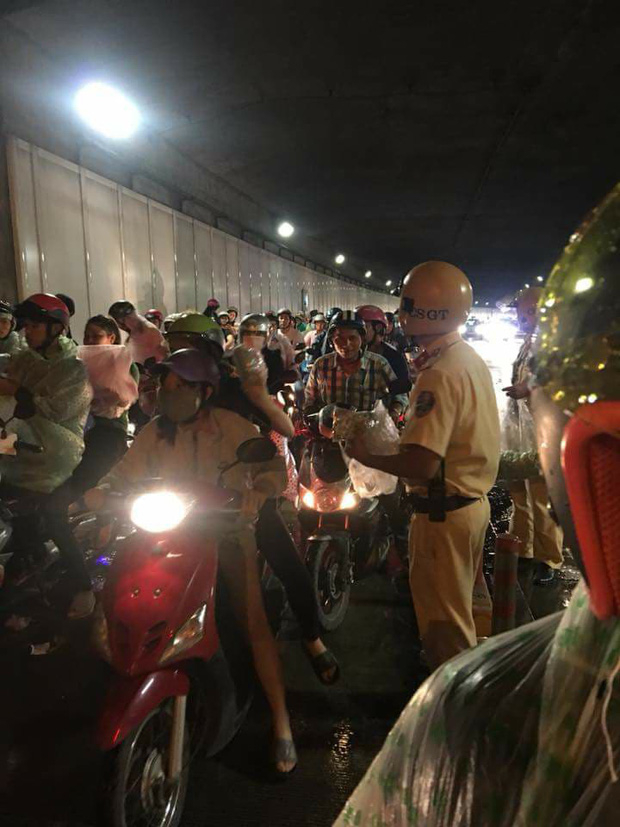 2 chiến sĩ CSGT phát áo mưa miễn phí