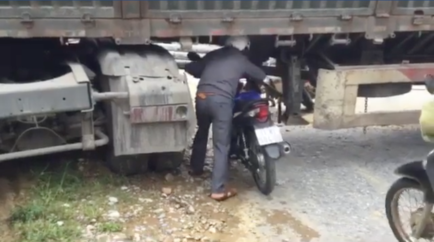 Xe đầu kéo mắc kẹt, người dân phải dắt xe máy chui