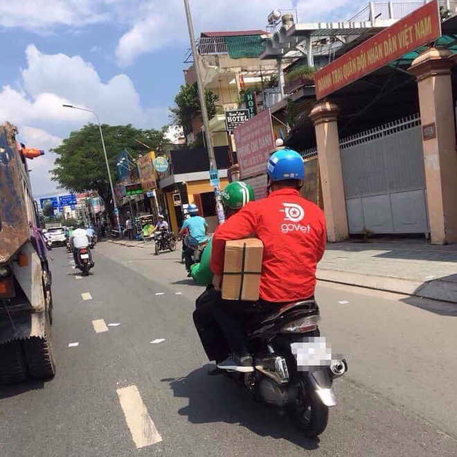 Thanh niên áo GrabBike đèo bạn áo Go Việt, đội mũ 