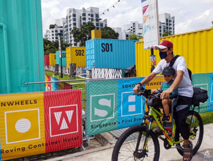 man-cycling-past-sg-hotel-on-wheels