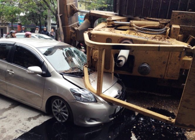 Chiếc xe 4 chỗ ngồi bị máy ủi rơi trúng - Ảnh: Doãn Hòa