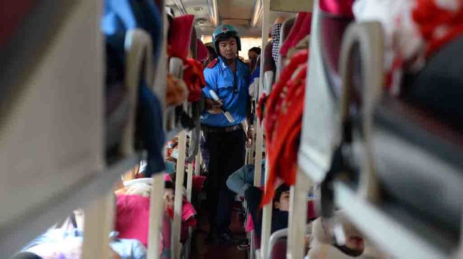 Cán bộ Đội 3 Thanh tra Sở giao thông vận tải TP.HCM kiểm tra số ghế ngồi một xe khách đưa người dân về quê ăn Tết tại bến xe miền Đông sáng 1-2