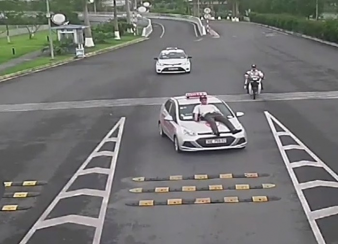 nhan-vien-bao-ve-nam-tren-nap-capo-cua-xe-taxi-anh