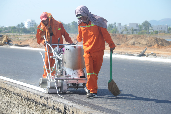 Công nhân đang làm giải phân cách đoạn qua khu đô thị vịnh An Hòa, thị trấn Núi Thành.